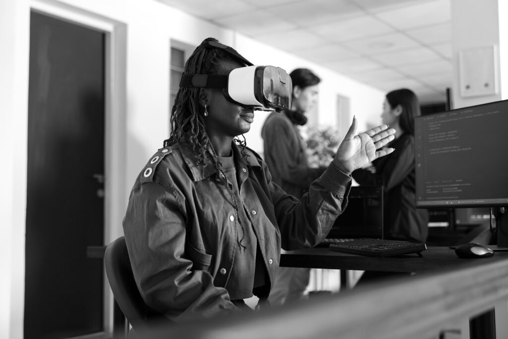 A young woman uses a VR headset at her desk as part of a learning programme.