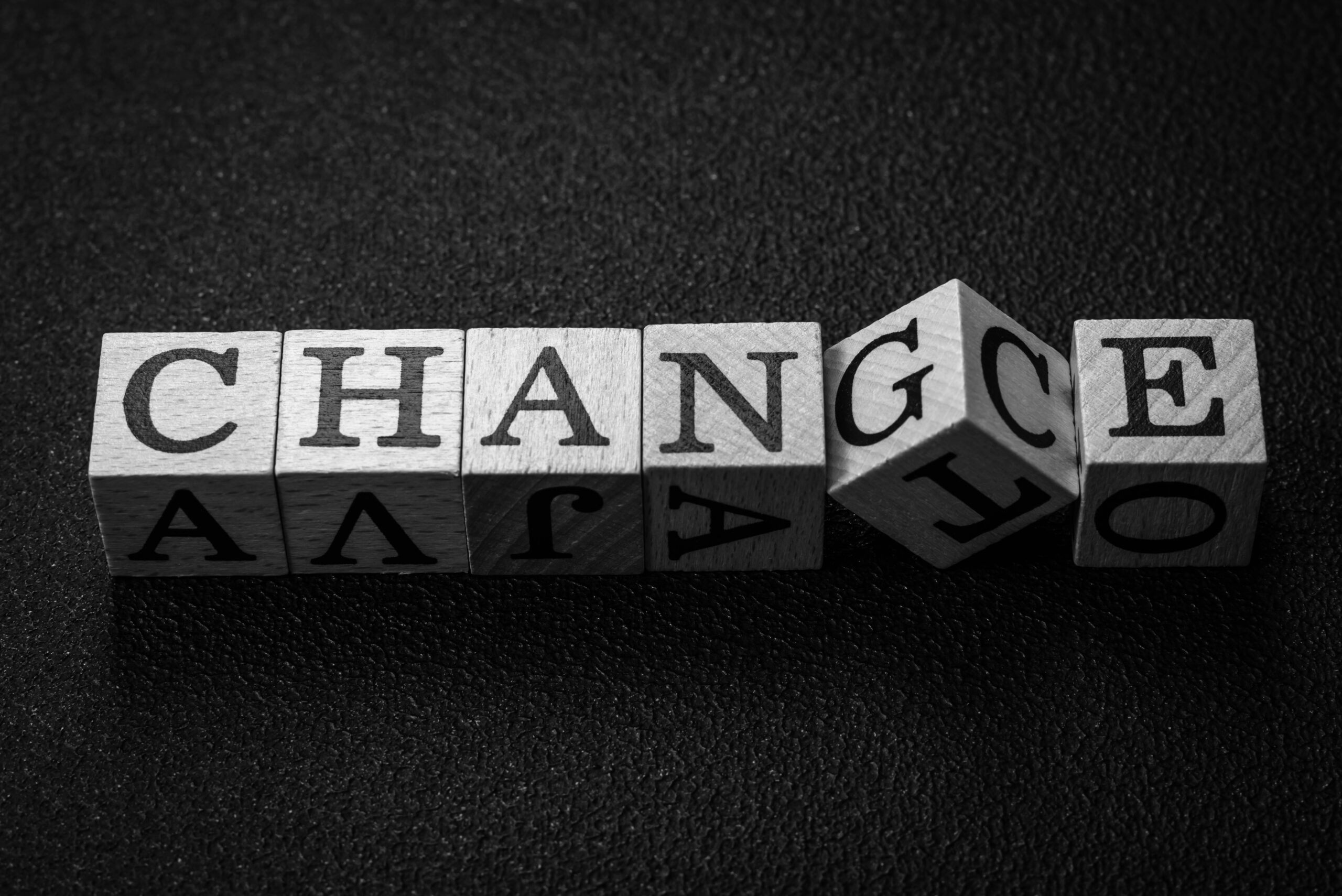 Alphabet building blocks are arranged to spell the word 'change'.