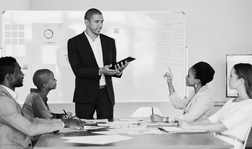 A young man presents to a team of people.