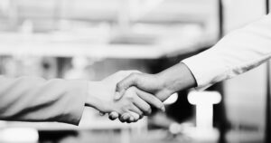 Two business people shake hands after closing a deal.