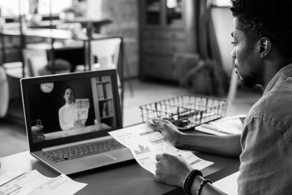 A young man engages in a remote call with a colleague.